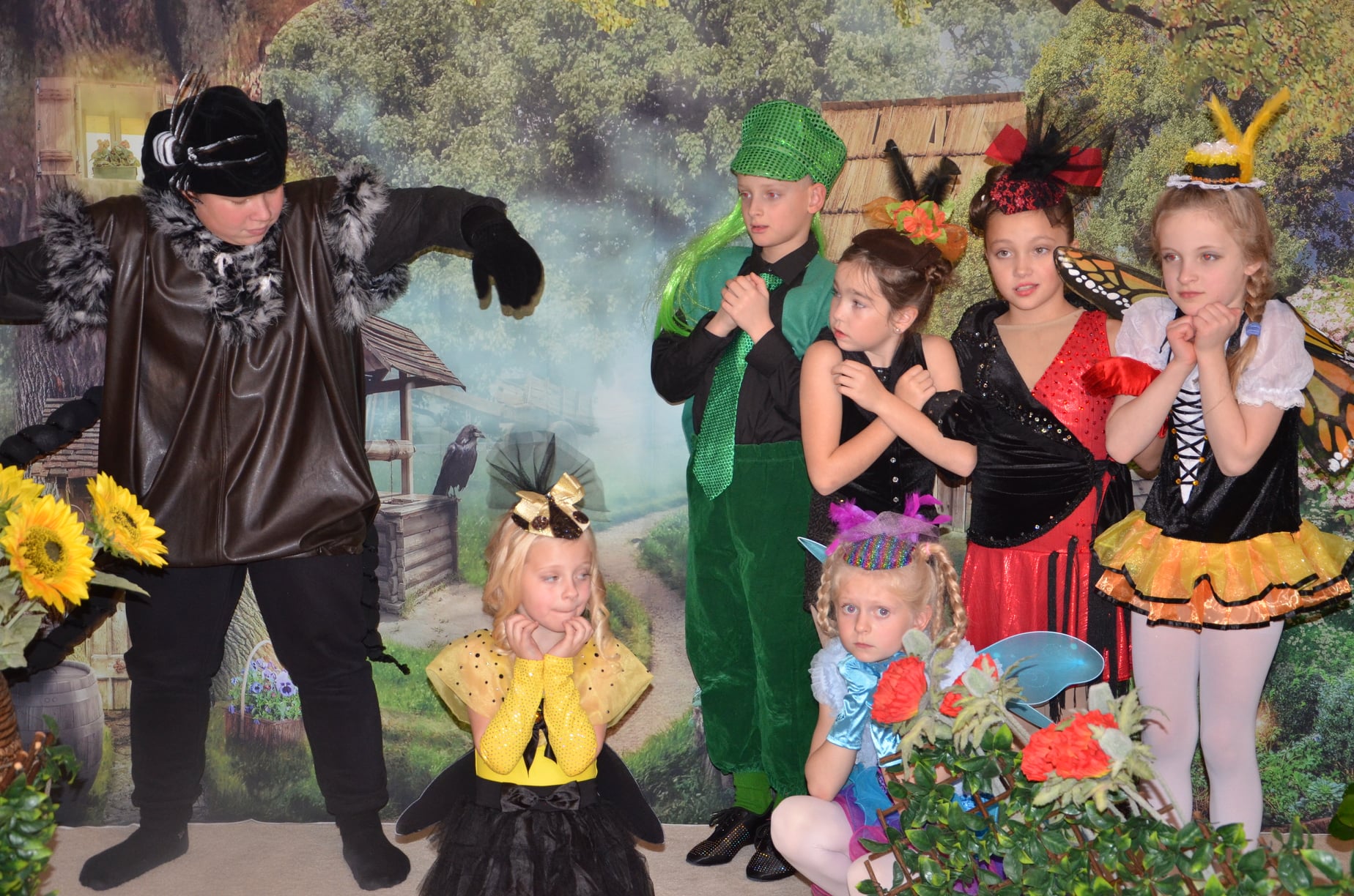 A group of child actors dressed as bugs performing on stage