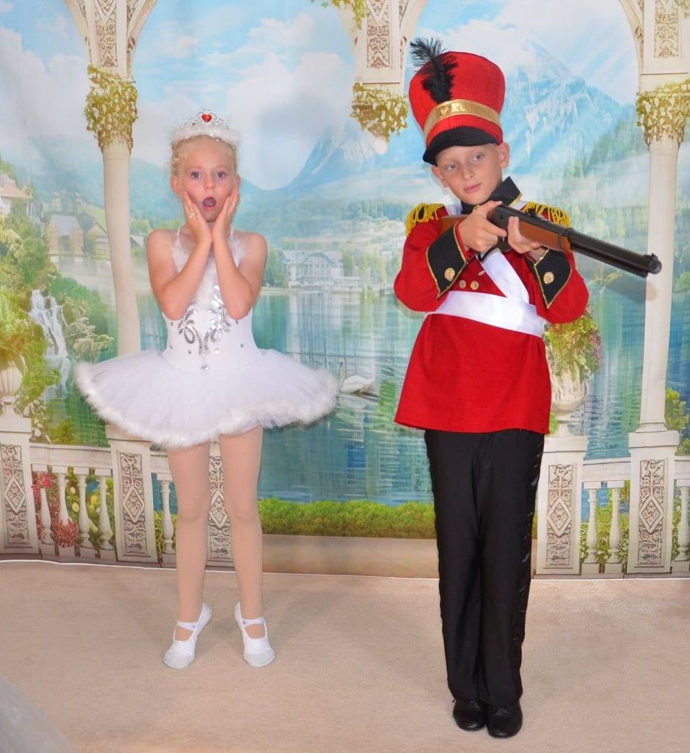  Two kids dressed in vibrant costumes in a performance